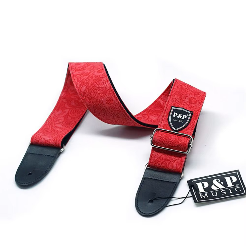 Esta vibrante correa de guitarra roja presenta intrincados patrones de paisley y una hebilla de metal resistente para un accesorio seguro