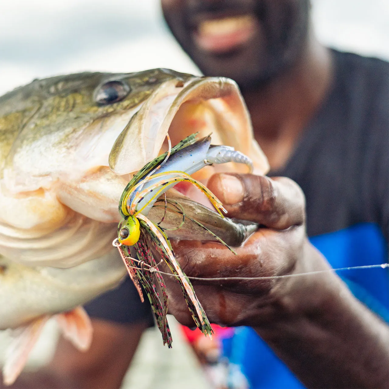 Un hombre que sostiene un pez con un señuelo en la boca