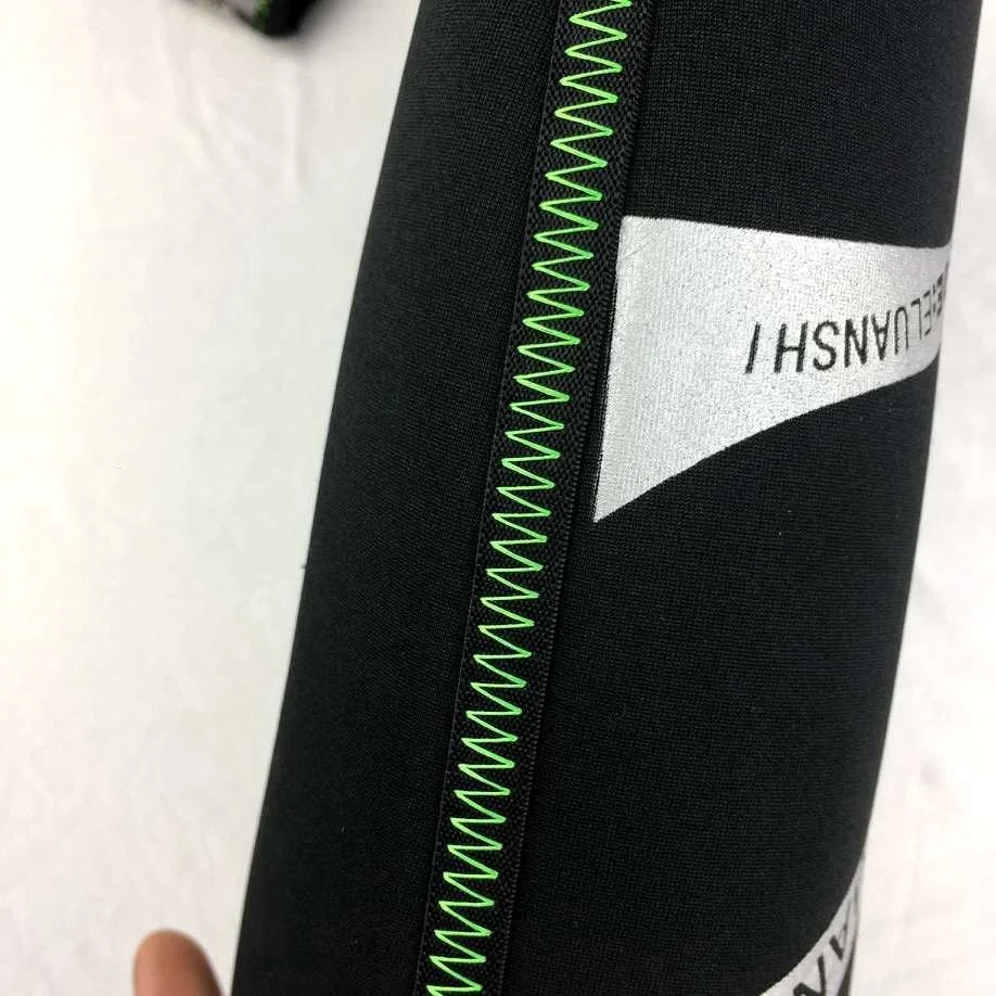 Una elegante tela negra con una vibrante costura de zigzag verde, enfatizando la durabilidad y el estilo