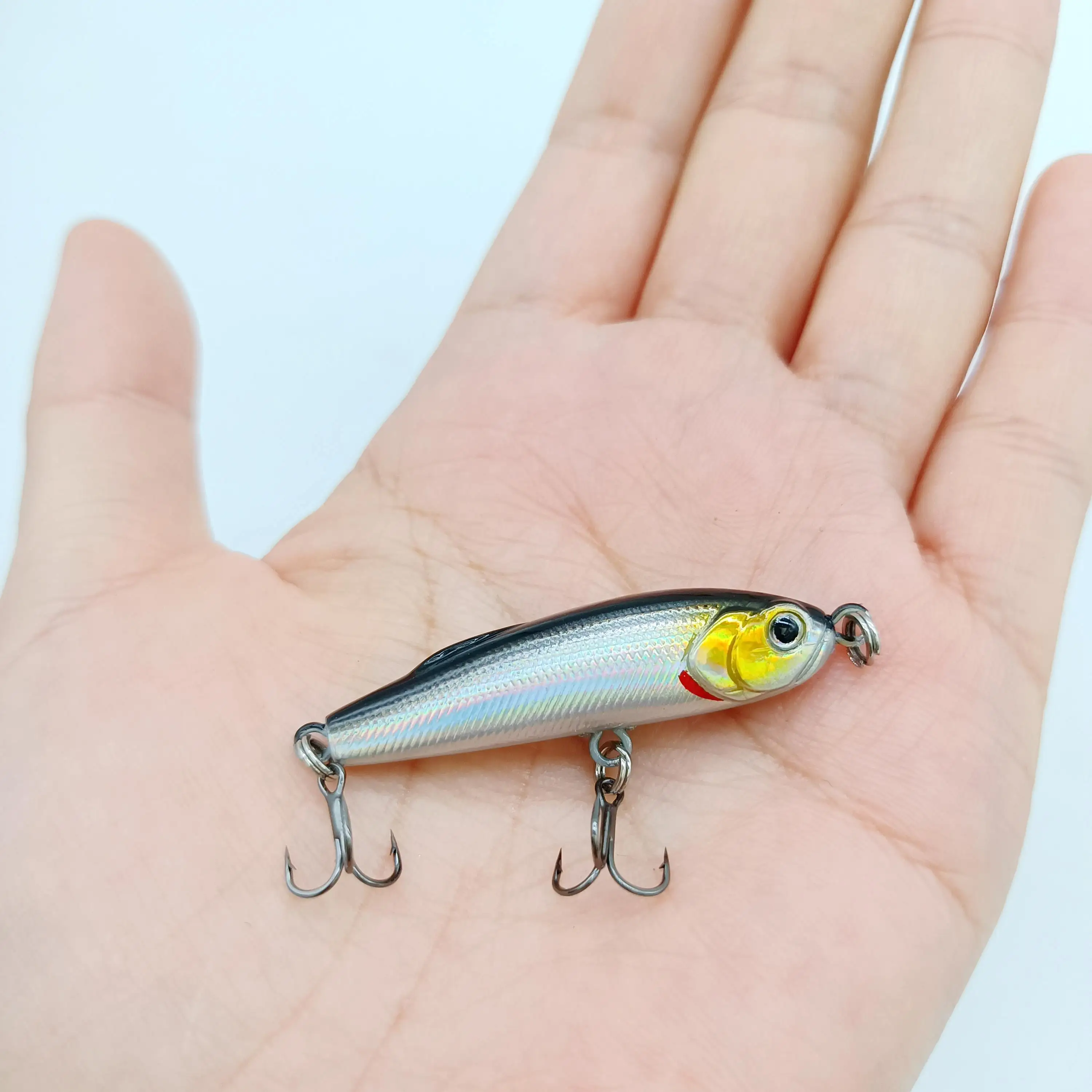 Un pequeño señuelo de pesca con dos ganchos de agudos diseñados para captar peces