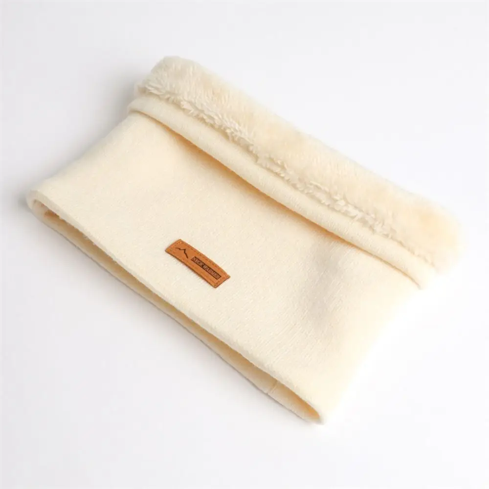 Una acogedora tela de color crema con un borde suave y esponjoso y una etiqueta de cuero