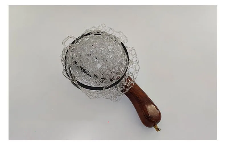 Descubra un diseño innovador con esta lupa única con un mango de madera y una intrincada malla de metal