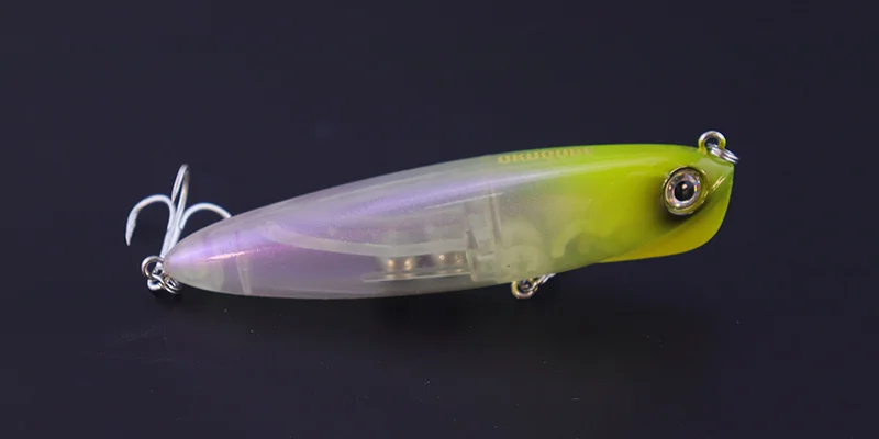 Un señuelo de pesca translúcida con una cabeza de color verde amarillo y un cuerpo blanco