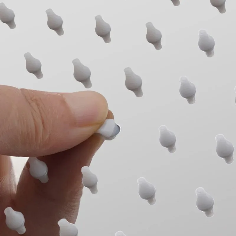 Una mano apunta a una pared de figuras de pájaros blancos