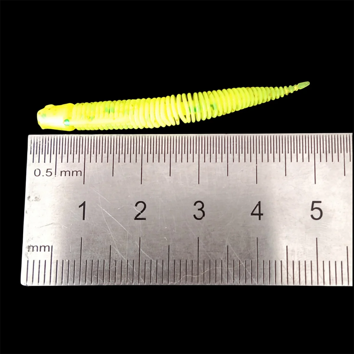 Un vibrante objeto amarillo en forma de espiral se muestra junto a una regla para la escala