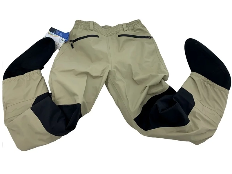 Un pantalón con un diseño único. Los pantalones son de color beige o marrón claro y parecen estar hechos de una tela que podría ser adecuada para actividades o deportes al aire libre.
