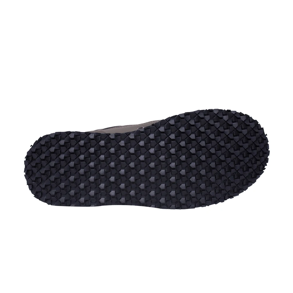 Un solo zapato, concretamente la suela de un zapato. Parece ser una suela negra con un patrón de pequeños puntos elevados o tacos, que normalmente se usan para tracción y agarre en la suela de los zapatos.