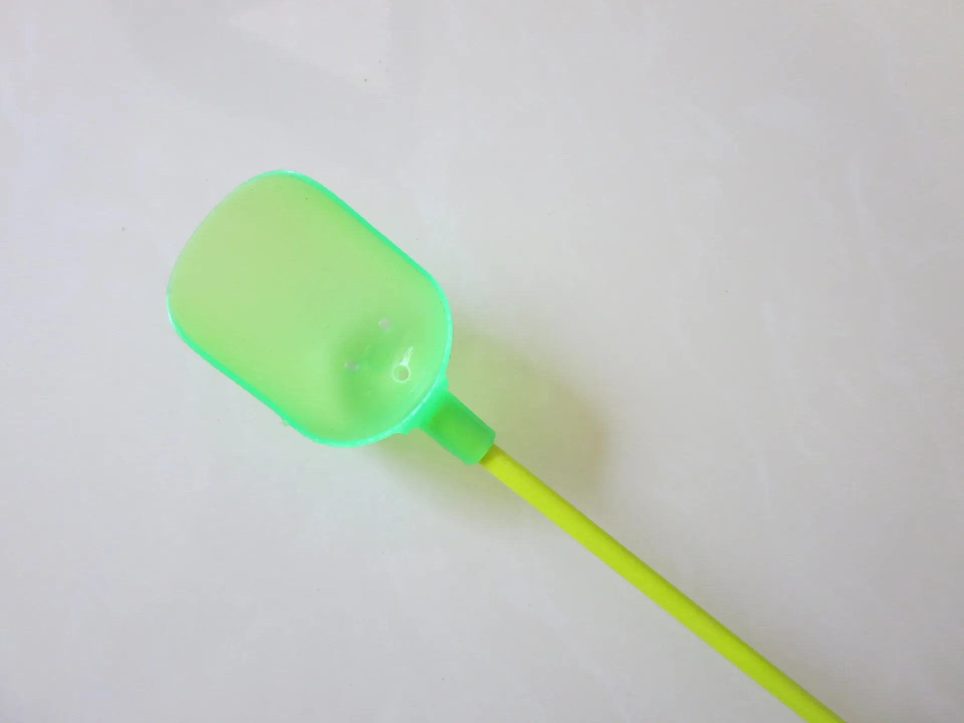 Una vibrante herramienta de plástico verde y amarillo diseñada para una fácil agarre y funcionalidad