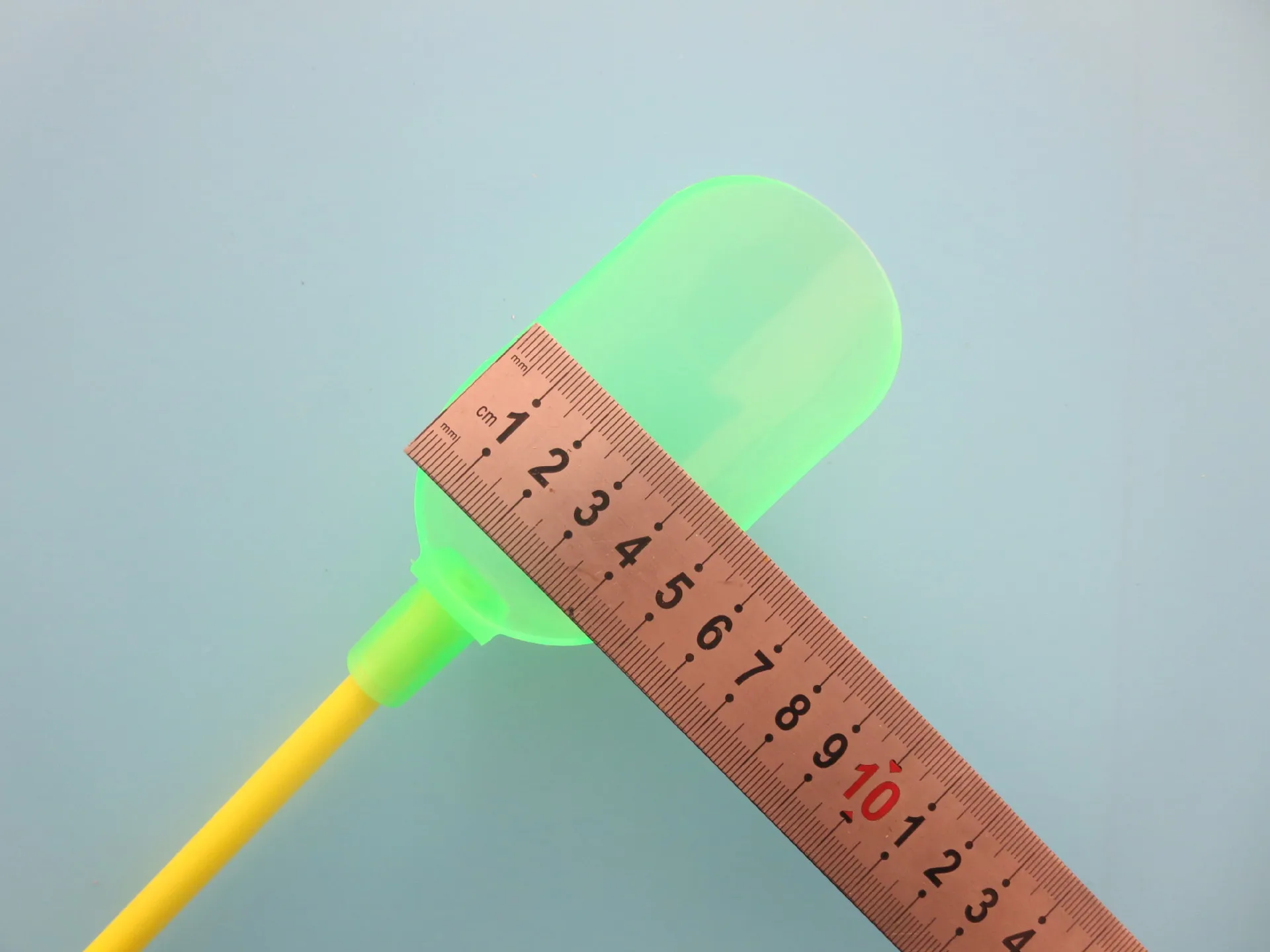 Mida las dimensiones de un objeto verde usando una regla amarilla