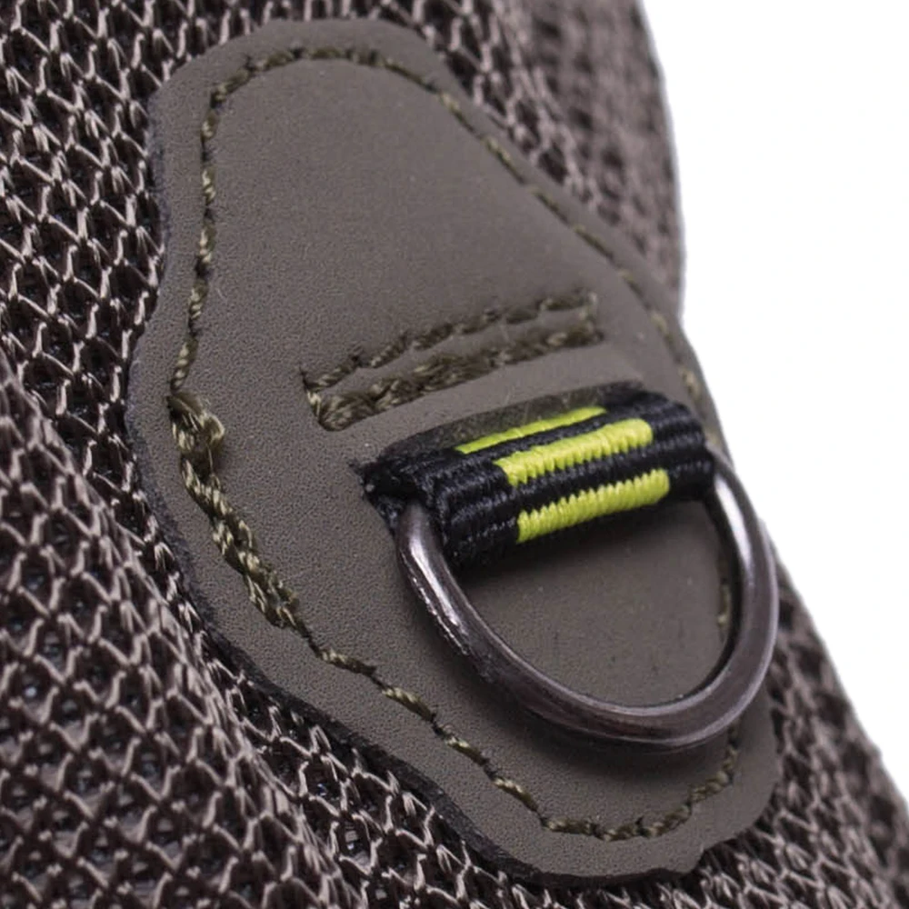 Un primer plano de un trozo de tela con tirador de cremallera. El tirador de la cremallera está diseñado con un lazo y un cordón, y tiene una combinación de colores amarillo y negro. La tela parece ser una malla o un material de punto, posiblemente parte de una prenda o un bolso.