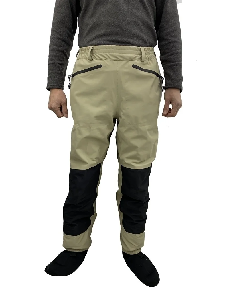 Una persona que usa un par de pantalones beige o de color claro con detalles en negro, como las cremalleras y la raya al costado de cada pierna.