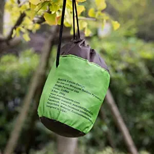 Una bolsa verde y marrón colgando de una rama de árbol