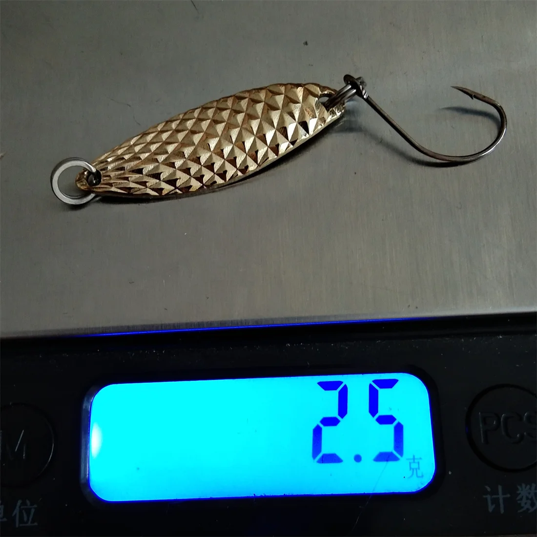 Un gancho de peces con un señuelo de oro está en una escala que lee 23