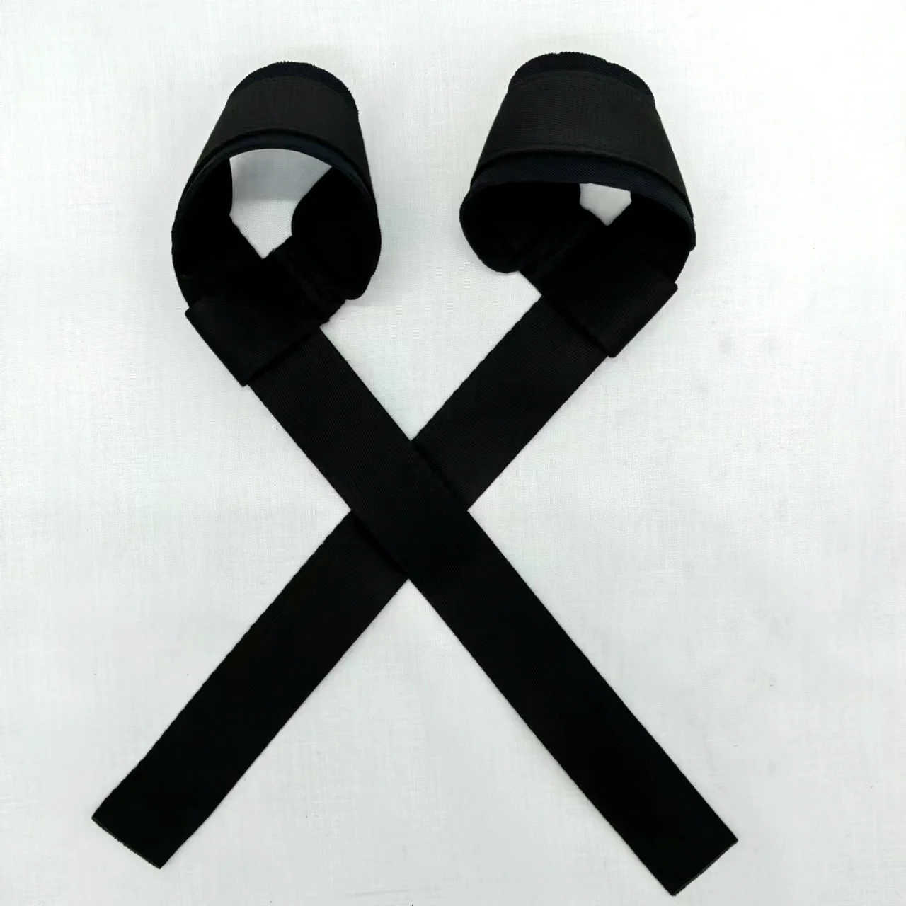 Un par de correas negras con presillas en un extremo, que parecen estar diseñadas para asegurar objetos o para usar en algún tipo de equipo. Podrían ser parte de un arnés, un sistema de seguridad o una pieza de equipo para actividades al aire libre.