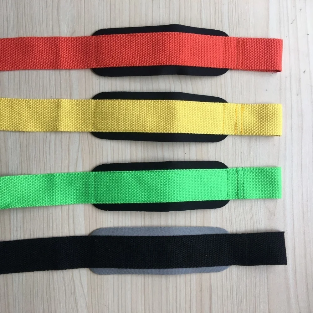 Un conjunto de cuatro muñequeras o muñequeras, cada una de un color diferente: rojo, amarillo, verde y negro. Se colocan sobre una superficie plana y cada banda tiene una sección elástica negra en un extremo, que probablemente se usa para asegurar la banda alrededor de la muñeca.