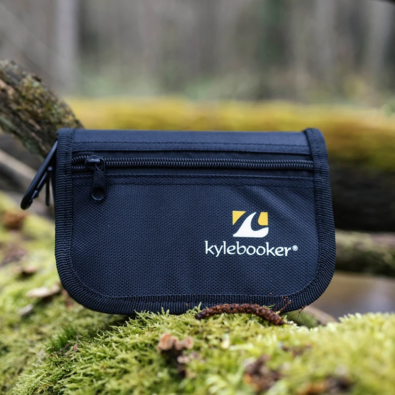 Bolsa de señuelos Kylebooker abierta sobre una roca con varios señuelos colocados