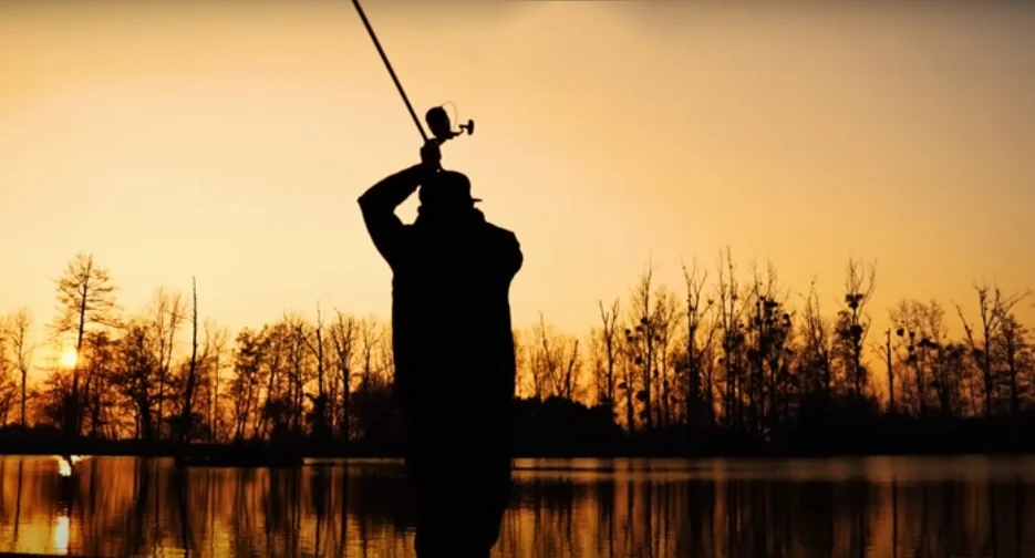 Pesca al atardecer con un telón de fondo de lago sereno
