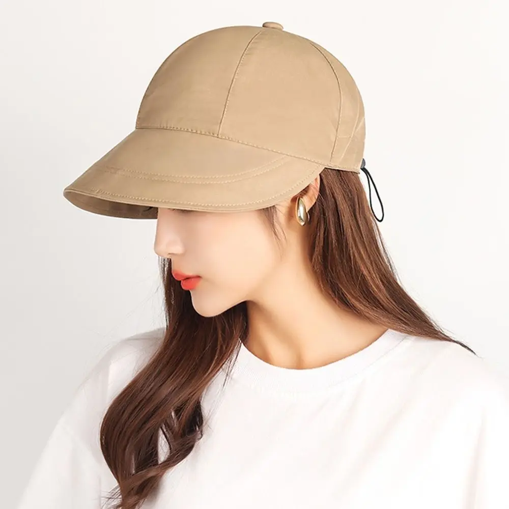 Una elegante gorra beige con una correa de barbilla perfecta para aventuras al aire libre