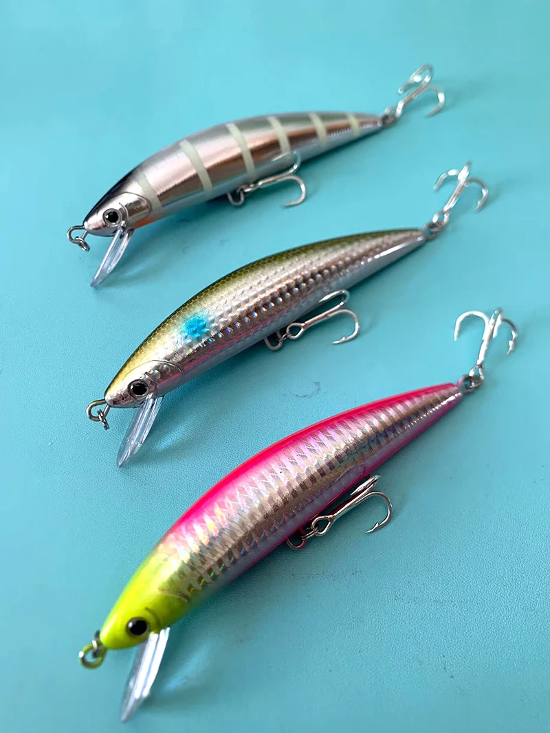 Se muestran tres señuelos de pesca sobre un fondo azul