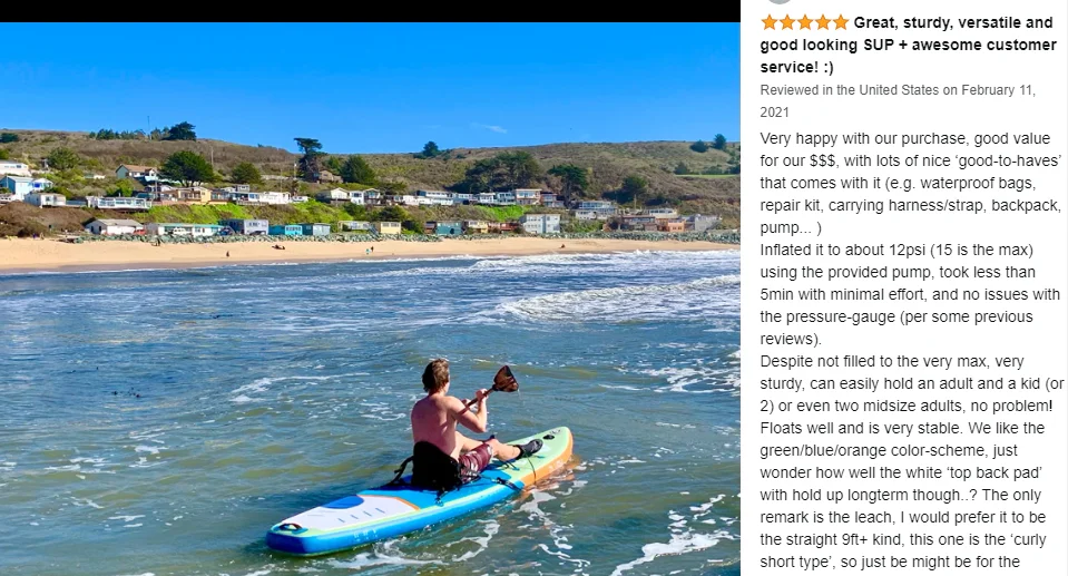 Un hombre está remando una tabla de surf en el océano