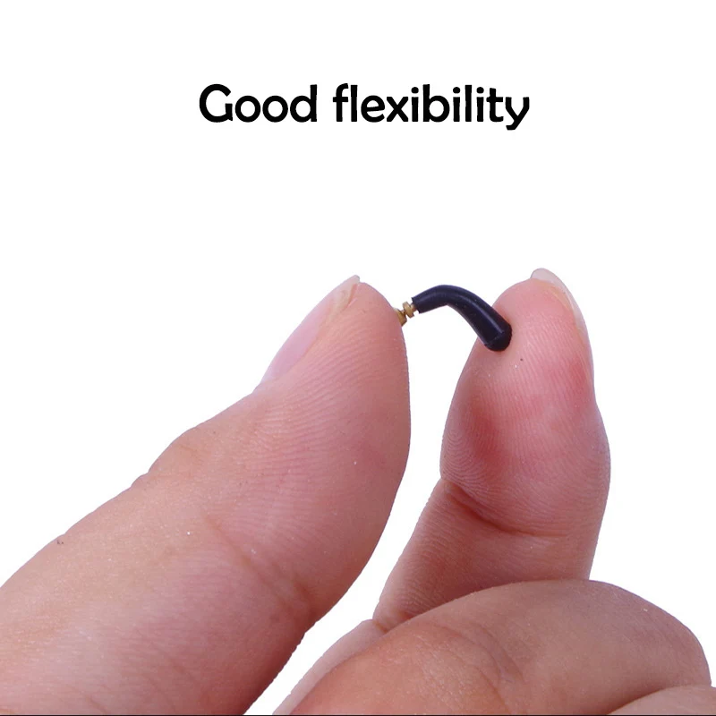 Un primer plano de los dedos de una persona sosteniendo un objeto pequeño y flexible. El objeto parece ser un cable o alambre con un conector en un extremo, posiblemente un cable USB o un tipo similar de dispositivo electrónico.