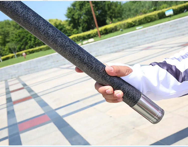 Una persona que sostiene un largo poste negro y plateado