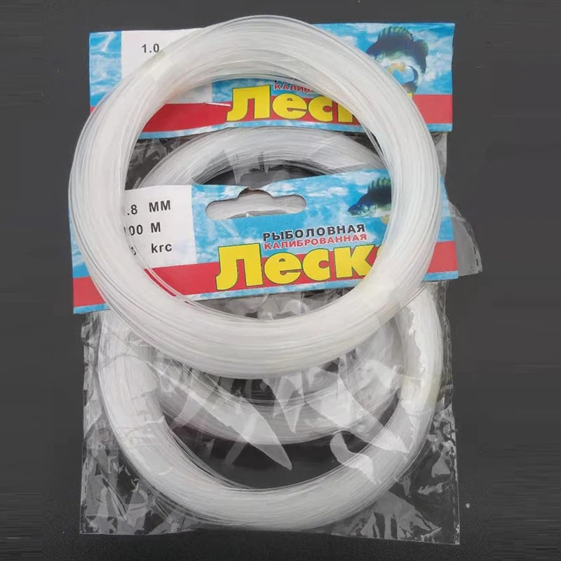 Carrete de hilo de pesca de nailon transparente sobre superficie de madera