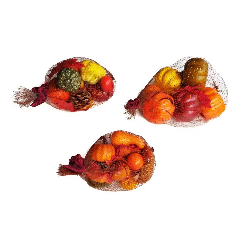 Detalle de hojas de arce de seda y frutas simuladas para mesa festiva
