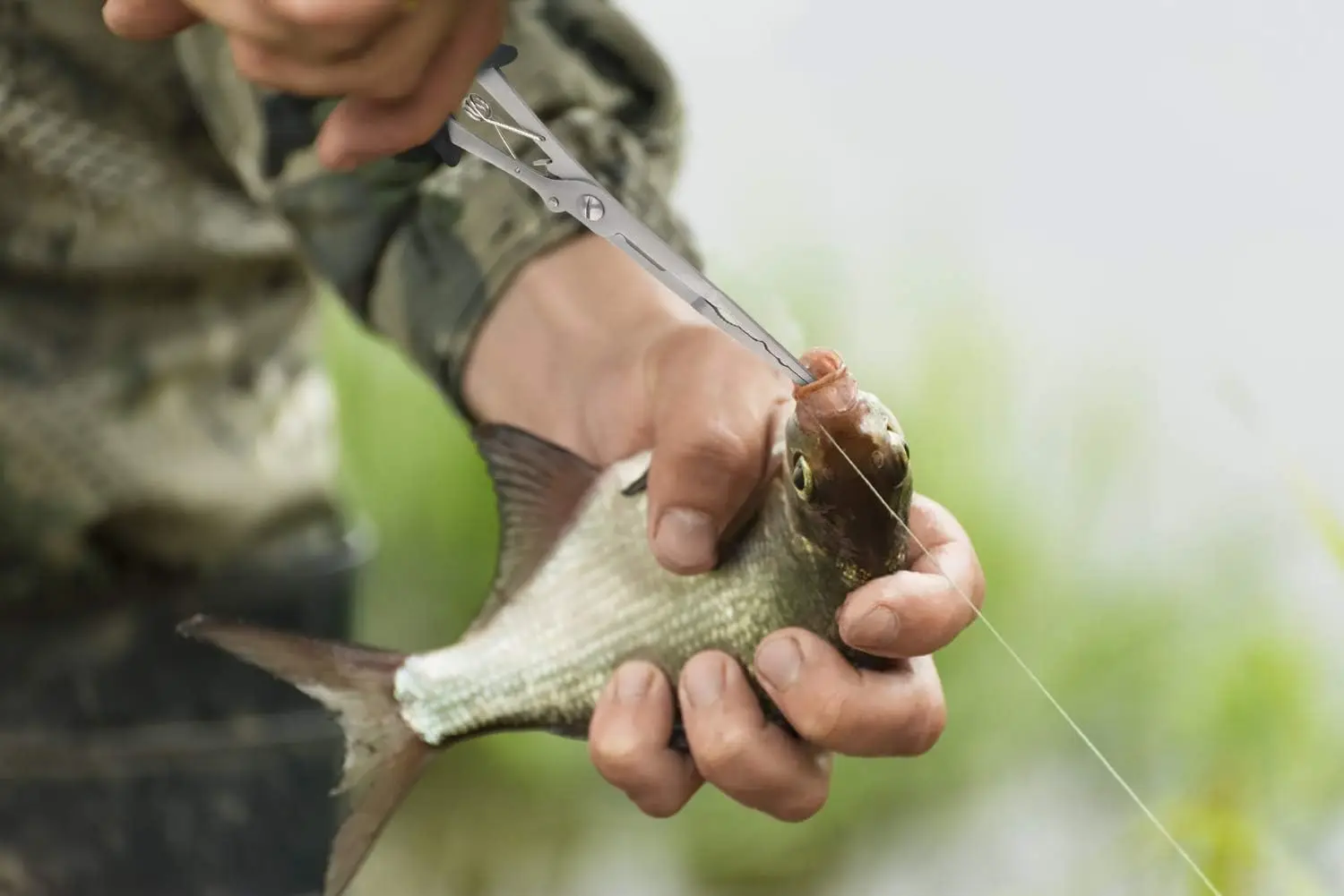 Alicates multifunción de pesca en mano