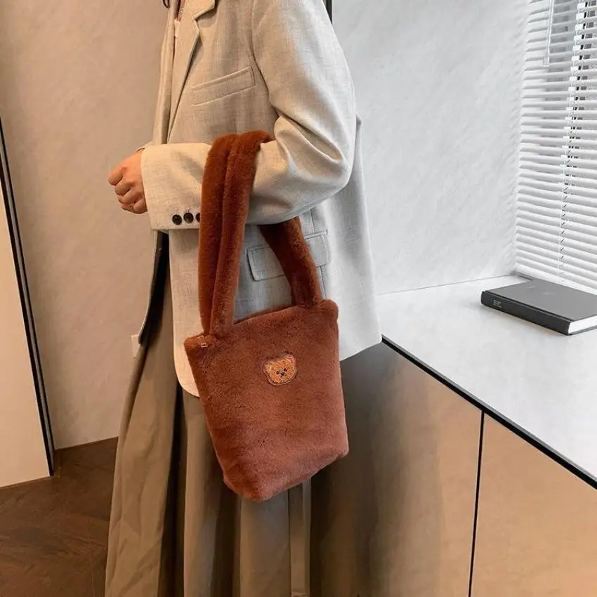 Bolso combinado con look de otoño, llevado en la mano