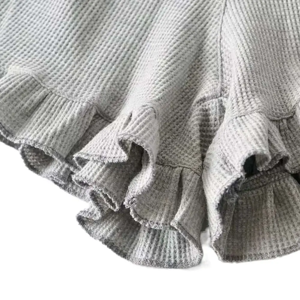 Vista frontal de los shorts en color gris con volantes laterales