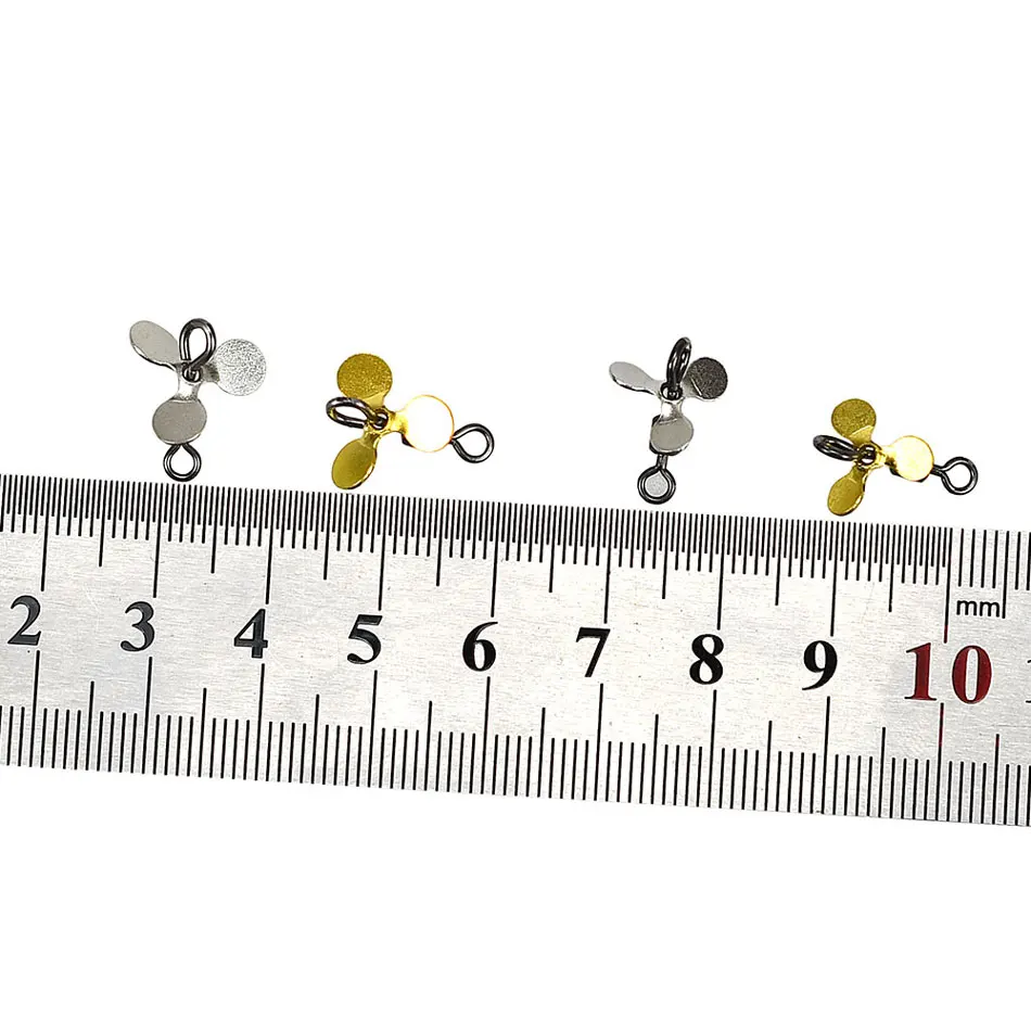 Comparación de palas doradas y plata al lado de una regla que indica tamaño aproximado