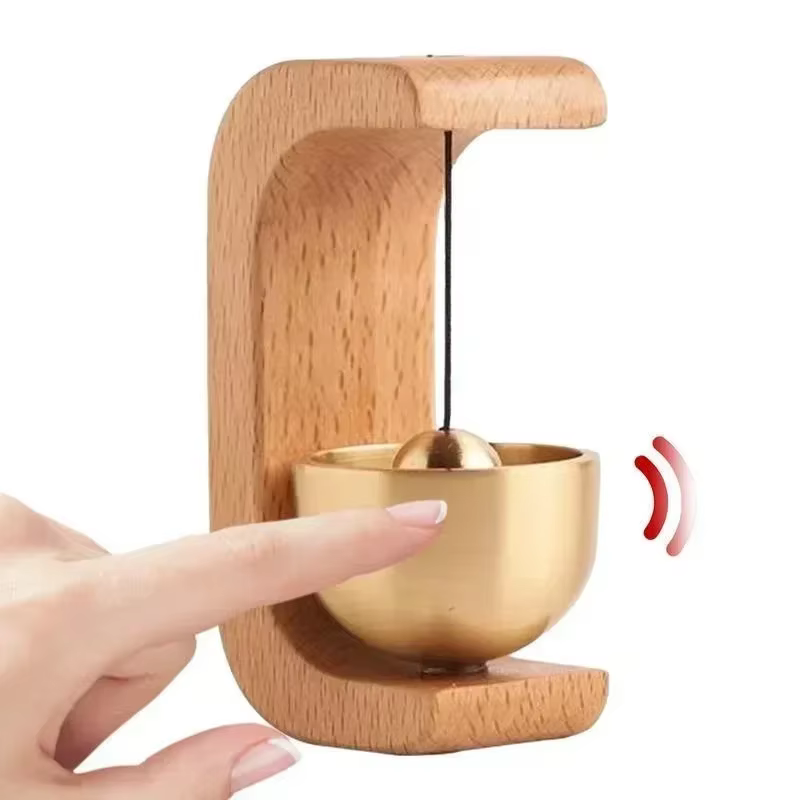 Timbre magnético de madera con campana de cobre sobre una puerta metálica