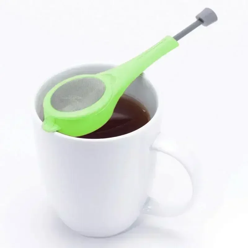 Colador dentro de una taza de té humeante