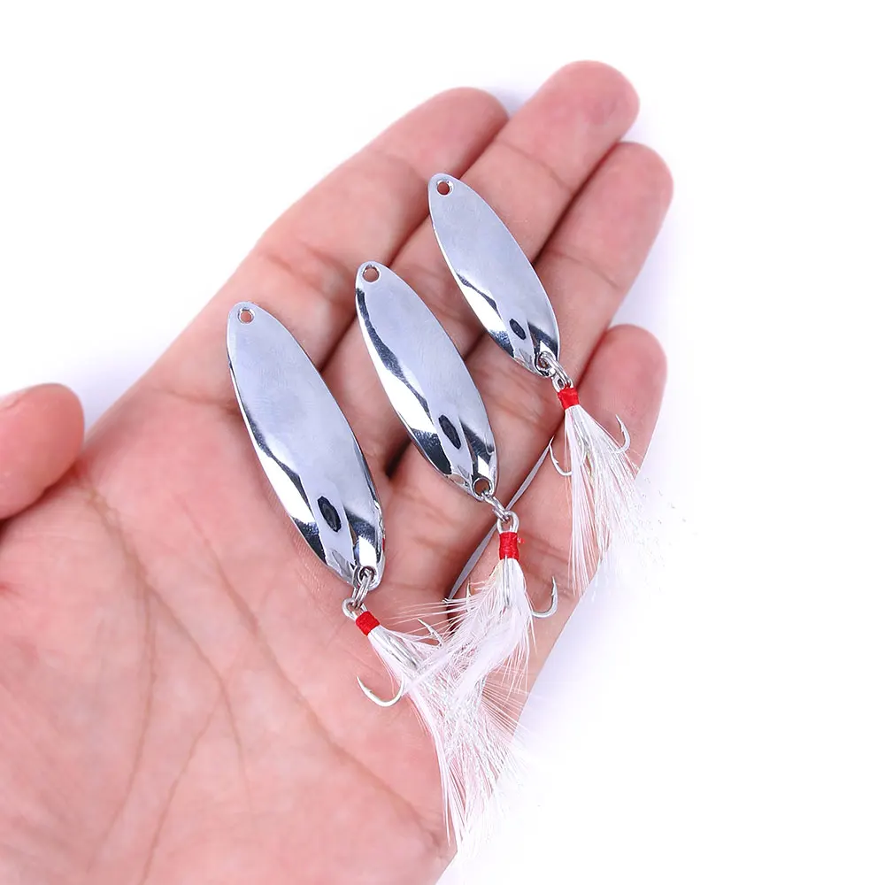 Señuelo tipo cuchara con anzuelo triple emplumado en detalle