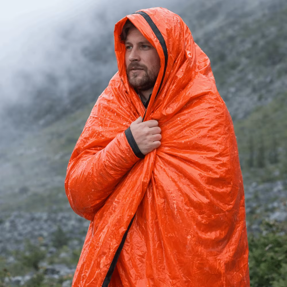 Saco de dormir de emergencia en uso durante actividad outdoor