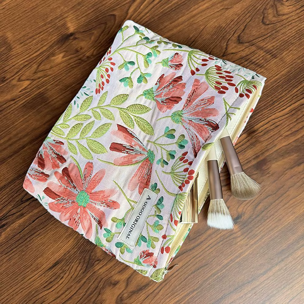 Bolsa de maquillaje beige y verde Dasiphora Fruticosa colocada junto a productos de cosmética