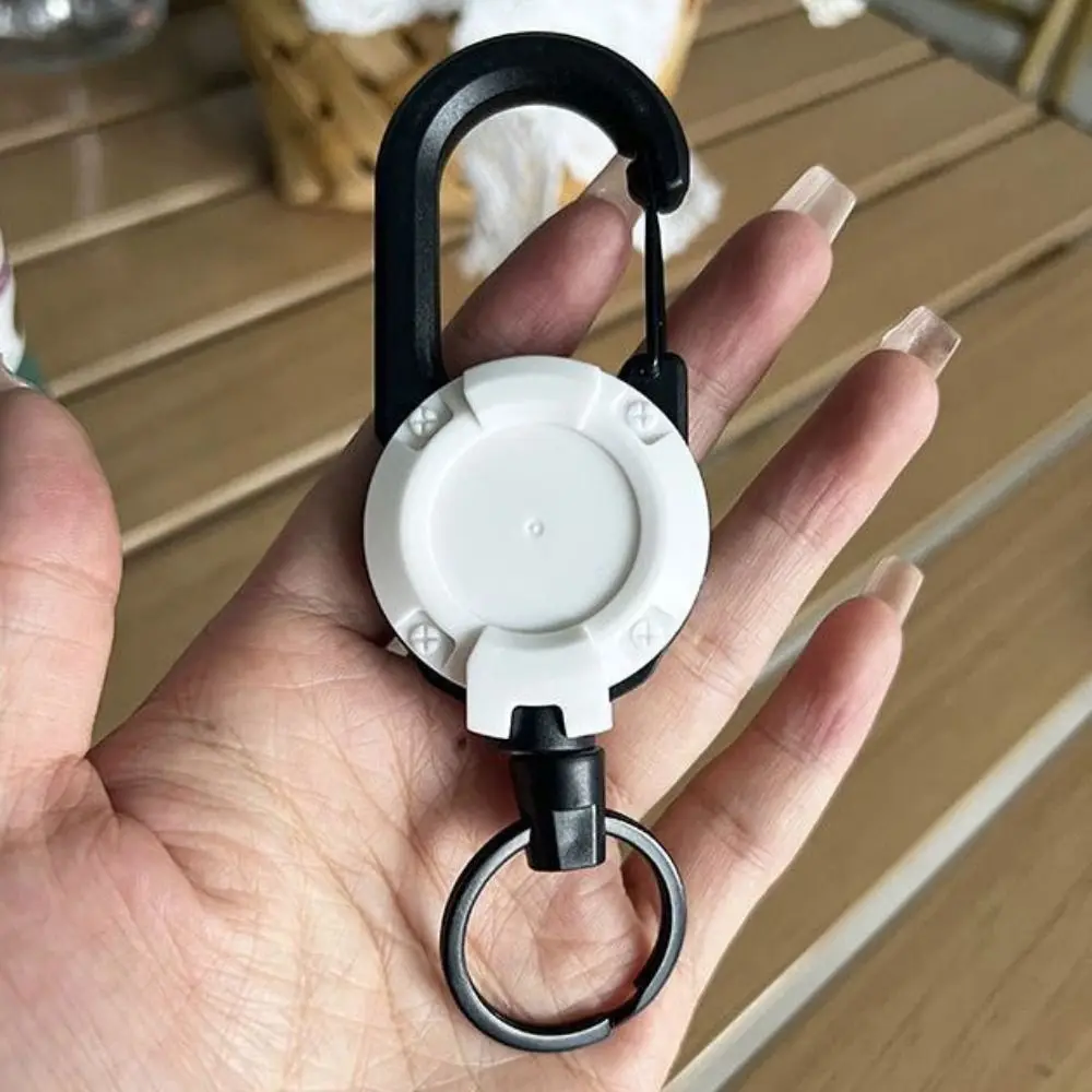 Detalle del mosquetón de aluminio con resorte y cuerda de acero retráctil