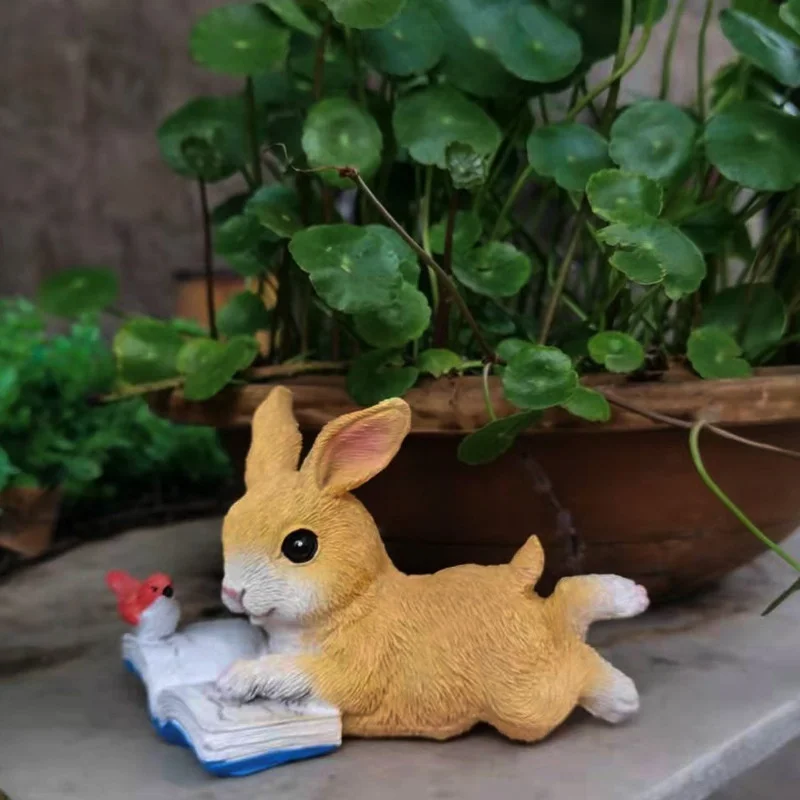 Conejo leyendo sobre una maceta de bonsái