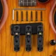 Puente de guitarra eléctrica de metal negro con tornillos y llave