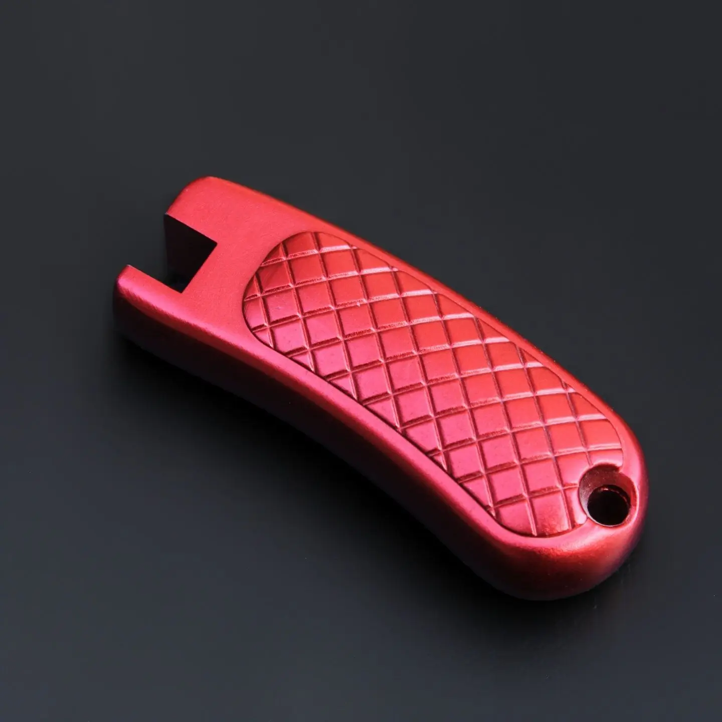 Detalle del agarre ergonómico y acabado anodizado rojo