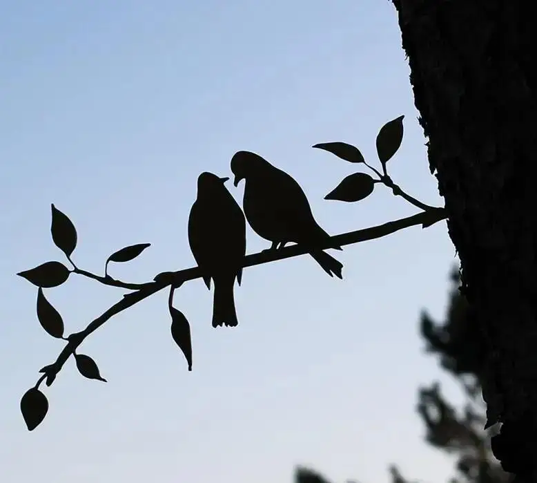 Golondrinas metálicas en rama de árbol
