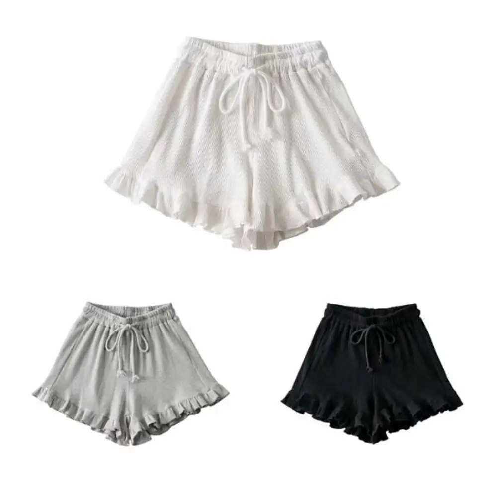 Mujer con pantalones cortos anchos y volantes en color blanco