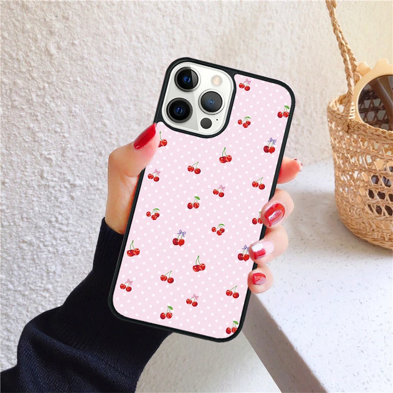 Funda para iPhone con diseño de cerezas rosadas, en mano